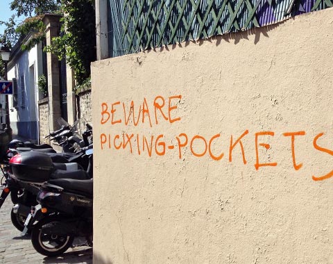 Graffiti on wall saying 'Beware pickpockets'