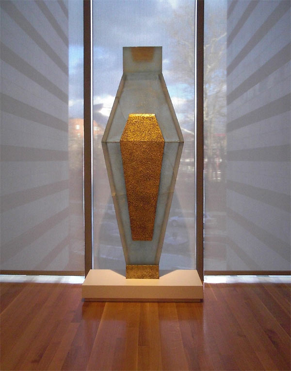 Tall glass sculpture facing window