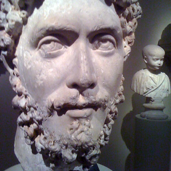 Stone head of man with curly hair and beard