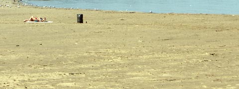 Two sunbathers on wide stretch of Edgewater Beach