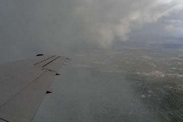 View of clouds and a little ground through plane window