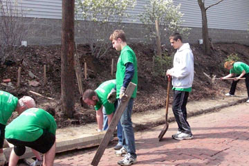 Group of people cleaning a brick alley