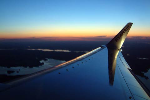 View from plane window showing lakes, etc. and setting sun