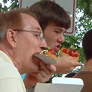 Two guys eating fruit tarts while watching rapper