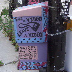 Street corner box that says Take a Video, Leave a Video