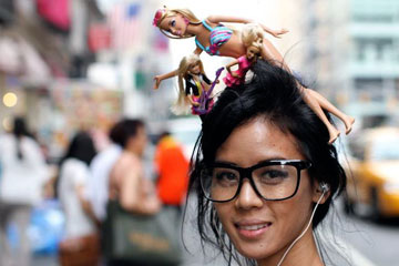 Woman with big glasses and Barbies on her head