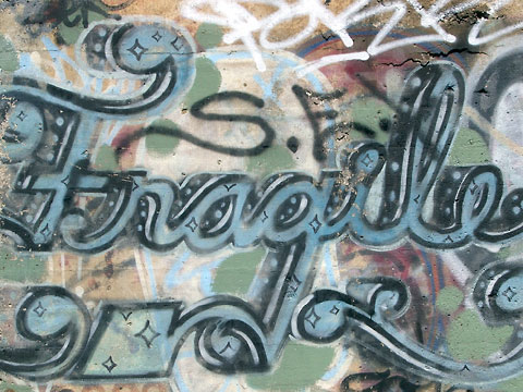 Graffiti on concrete wall, says 'Fragile'