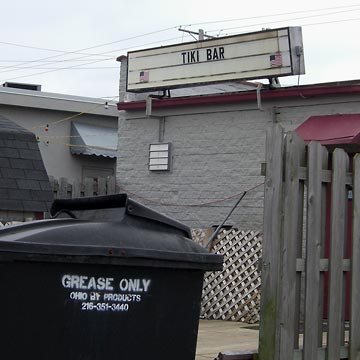 Sign saying Tiki Bar on dingy gray wall
