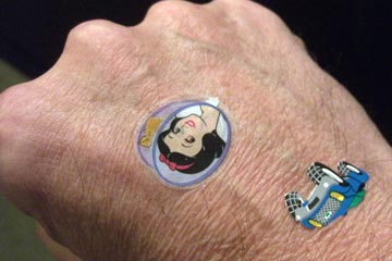 Close-up of the back of my hand with a Snow White and a blue car sticker on it