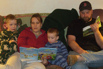 Sharon reading to Jack and Sam on couch, Ken reading also