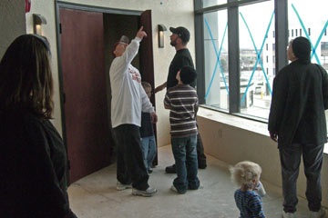Danny pointing to ceiling as other family members listen