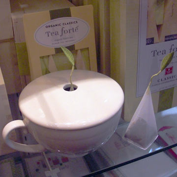 Tea cup with lid, leaf growing up through it