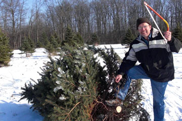 Al with saw, standing by tree