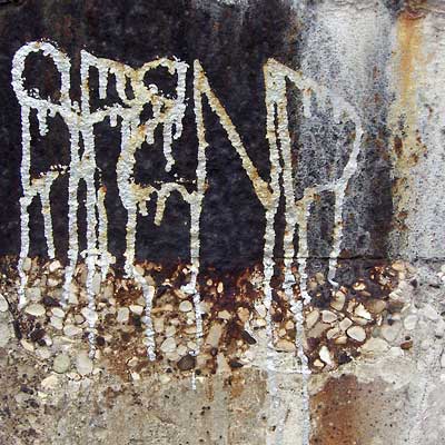 Cleveland graffiti, white drips on black, stained concrete