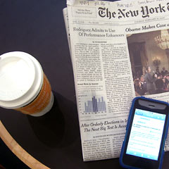 Overhead view of New York Times, coffee cup and iPhone