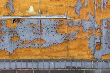 Foam, paint and brick on factory wall