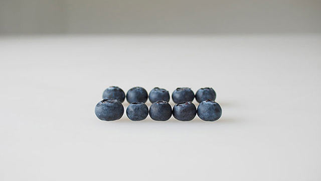 Blueberries lined up on white background
