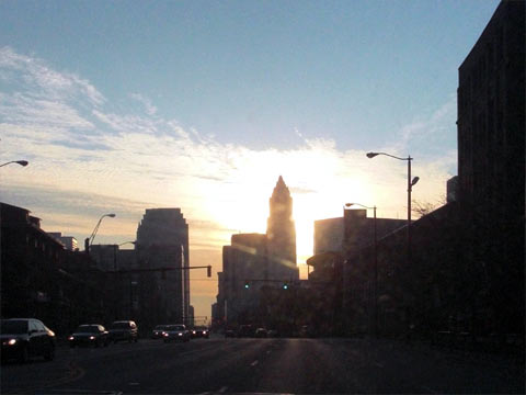 Sun shining behind downtown Cleveland skyline