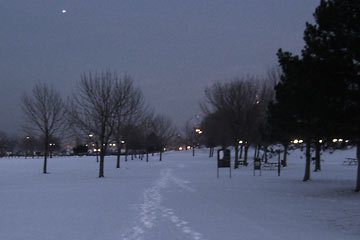 Snowy path through the park, with bright footprints