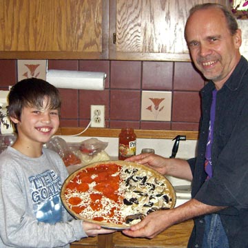 Pizza with tomato sauce and pepperoni on one side, mushroom and olive oil on the other