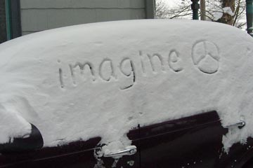 Side view of my car with "imagine (peace sign) written in the snow
