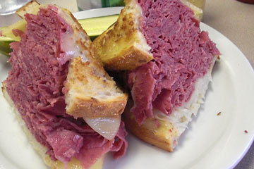 Huge Reuben sandwich, sliced on plate