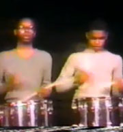 Two young drummers standing on stage
