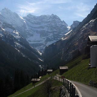 View from hostel with steep path down and snow capped mountains ahead