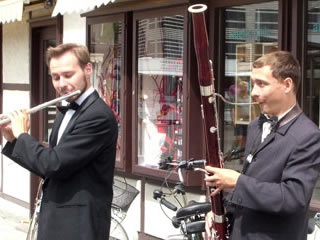 Two street musicians playing oboe and flute