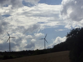 Wind turbines silhouetted against cloudy sky