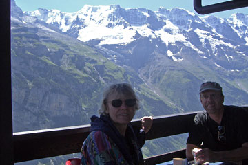 Al and Joanne sitting on the balcony with snow-covered peaks in background