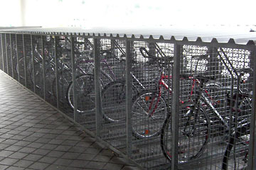 Row of wire-mesh lockers with bikes inside