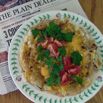 Hashbrown potatoes with tomato and parsley on top