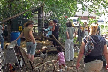 Chicken coop with  people standing around