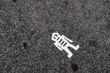 White skelton figure on black asphalt
