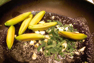 Daylilies, garlic and basil in frying pan