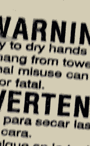 Towel dispenser hanging warning