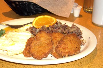 Plate of eggs, corned beef hash, potato pancakes