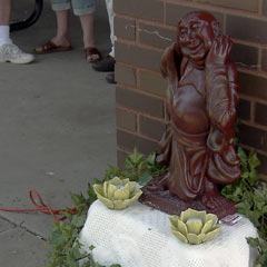 Statue of Buddha next to brick column at park