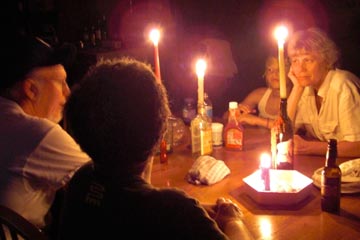 Anita, Jared, Joanne and Xavier playing cards by candlelight