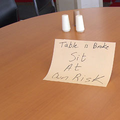 Cafeteria table with sign saying it's broken