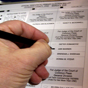 Hand marking an election ballot