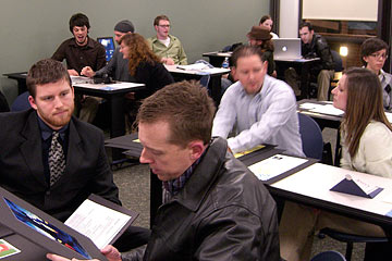 View of room with students and professionals talking