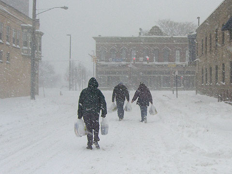 People carrying grocery bags walking down Bridge Ave.