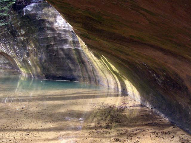 Stone overhang with pool of water below