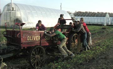 People pushing farm wagon