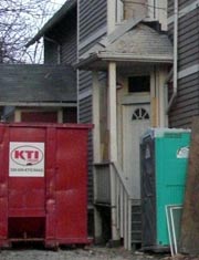 House with large dumpster in driveway