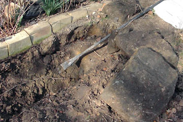 Trench in garden with large rocks alongside