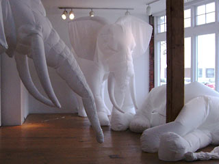 Inflated cloth elephants, two standing, one lying down.