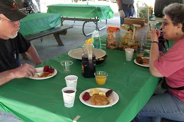 People at picnic table eating pancake breakfast
